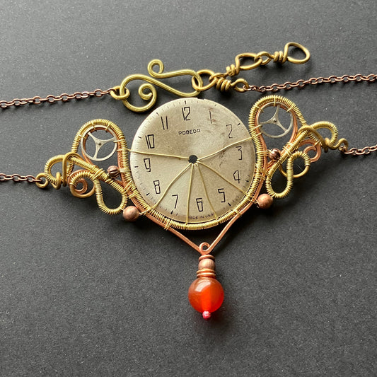 Decorative clock pendant with intricate design on a gray background