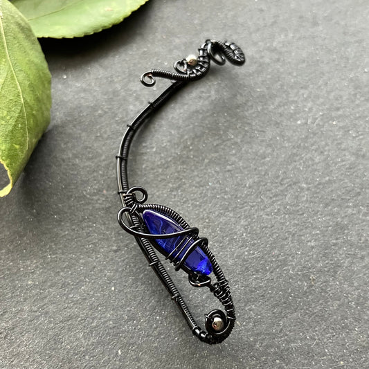 A black and blue ear wrap with intricate details and a gothic style.