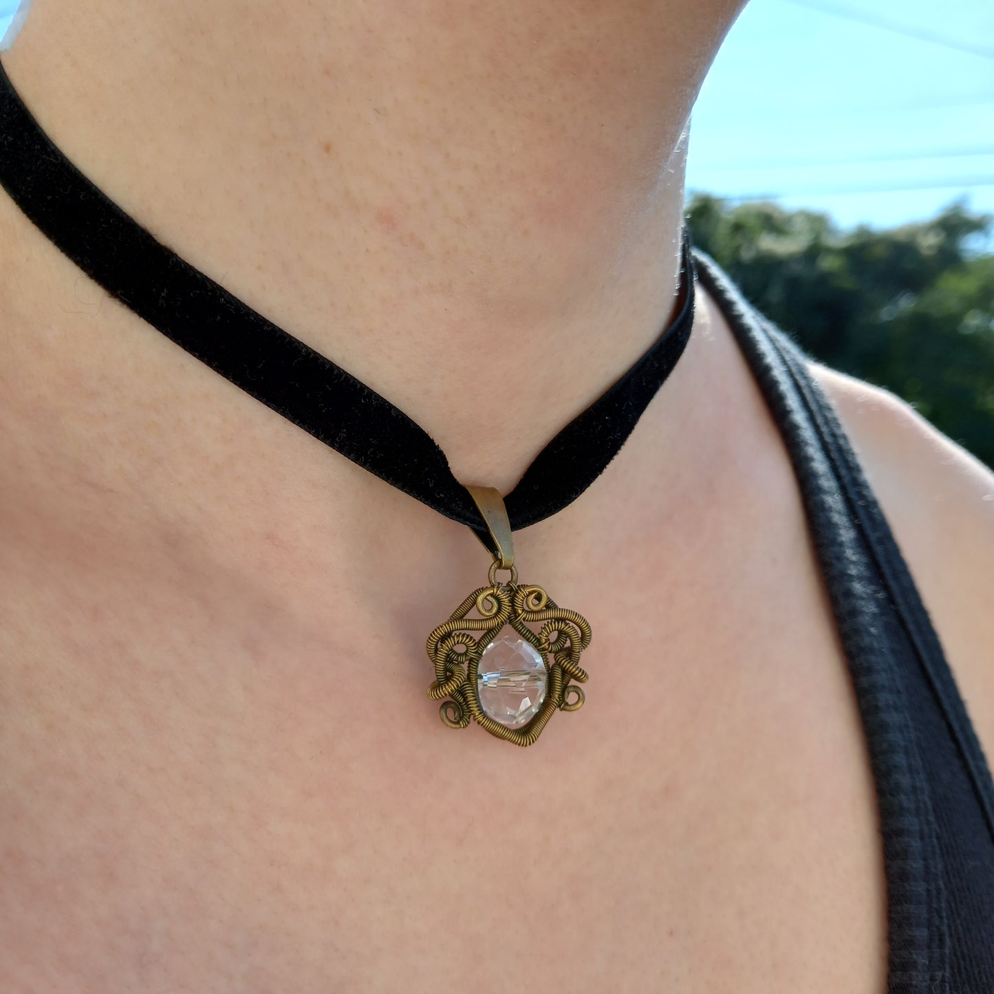 brass wire wrapped pendant with clear glass bead on black velvet choker