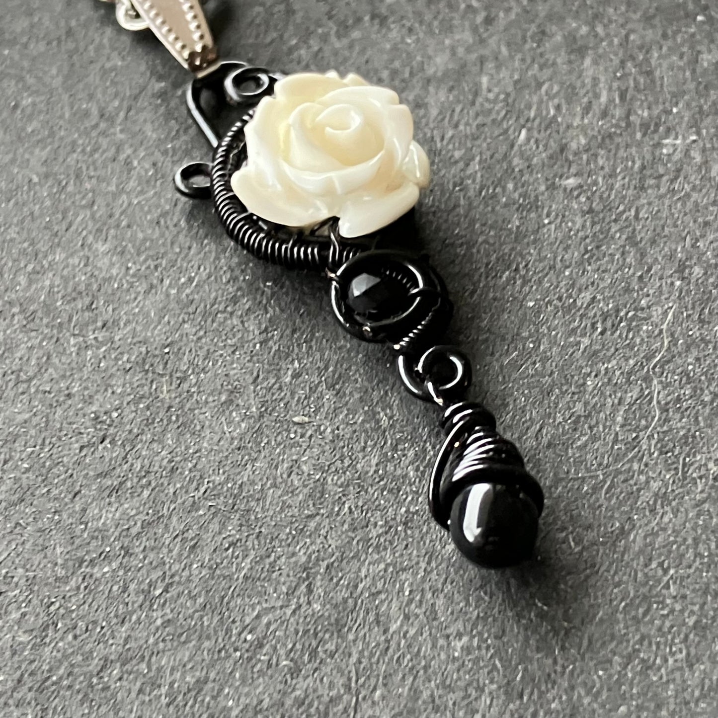 White rose and black necklace