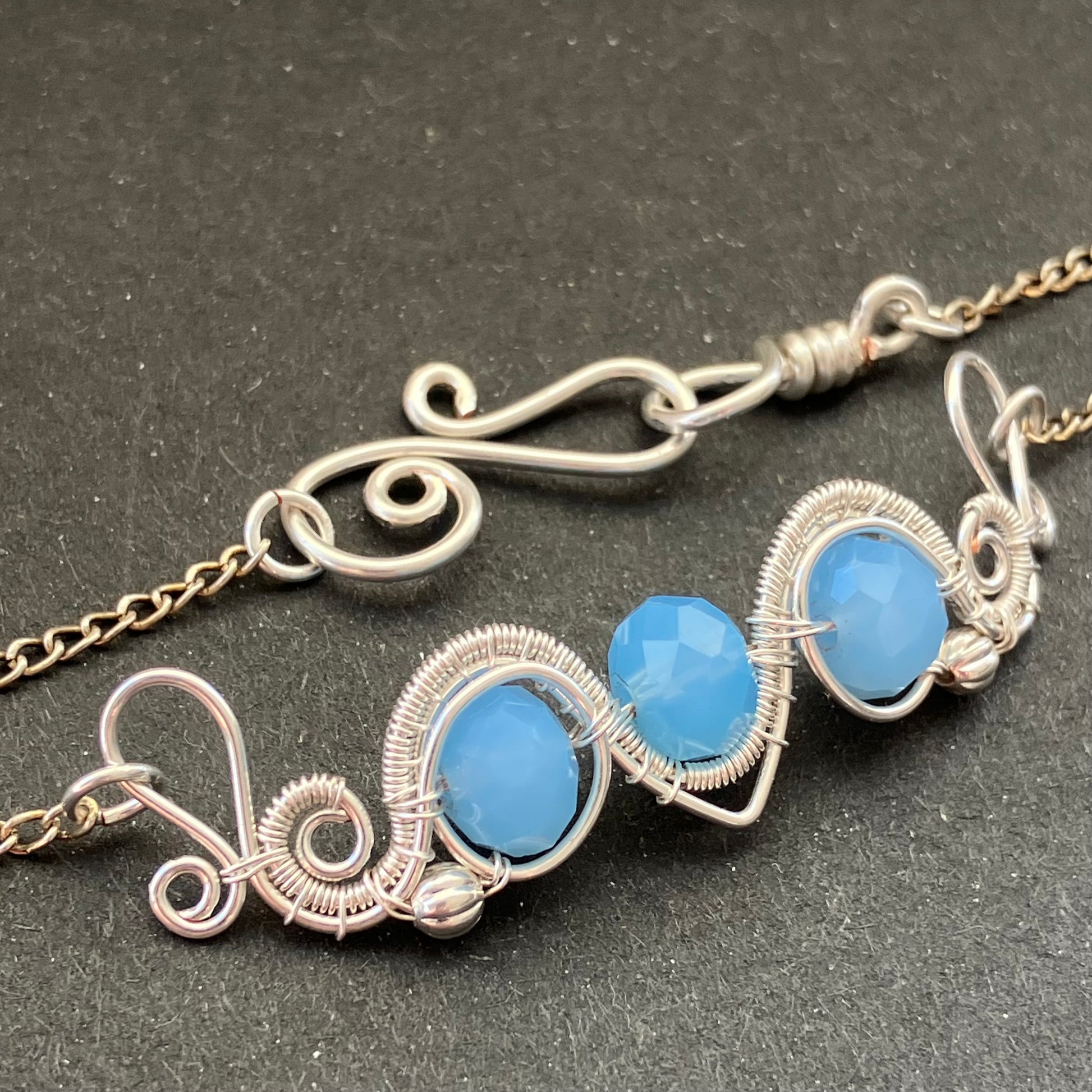 A silver-plated necklace with blue glass beads and decorative metalwork