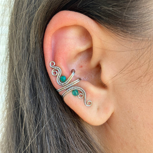 Close-up of an ear with a decorative silver and green onyx earring.