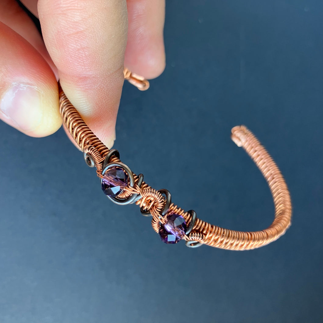 cuff style wire wrapped copper bracelet with translucent purple beads