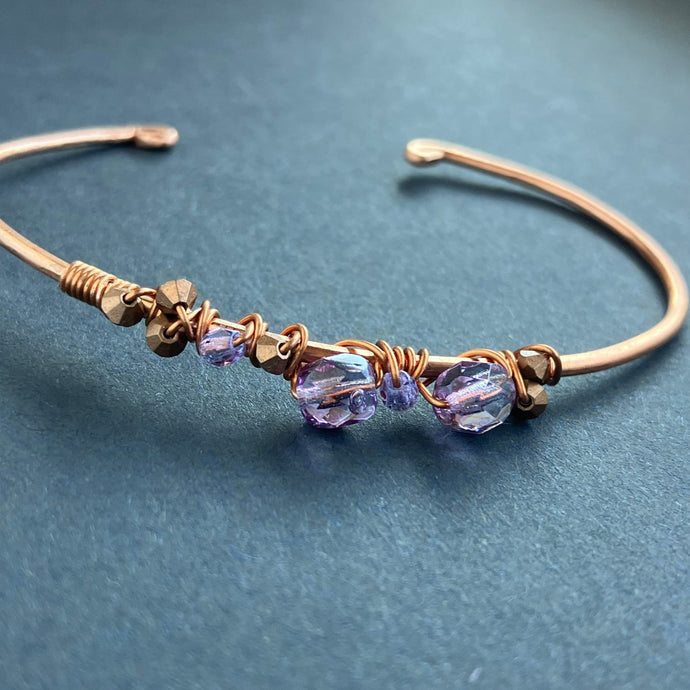 copper cuff style bracelet with translucent purple beads