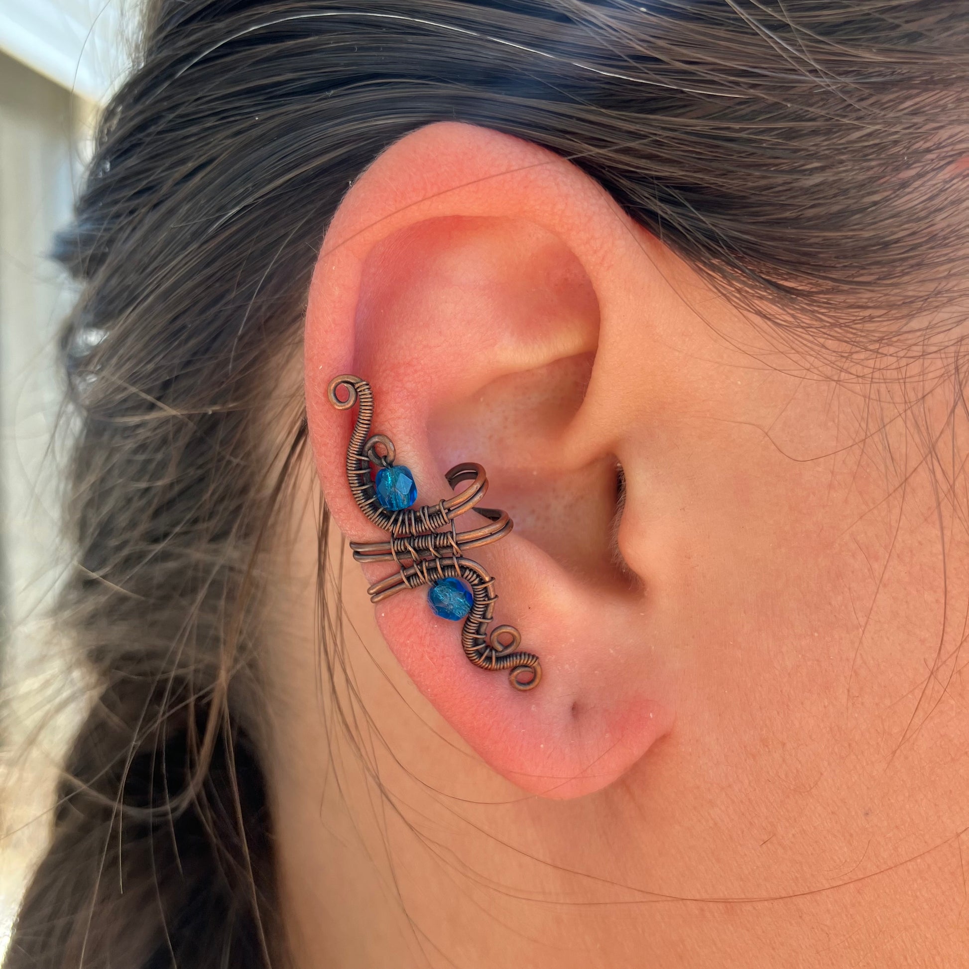 copper ear cuff with bright blue beads