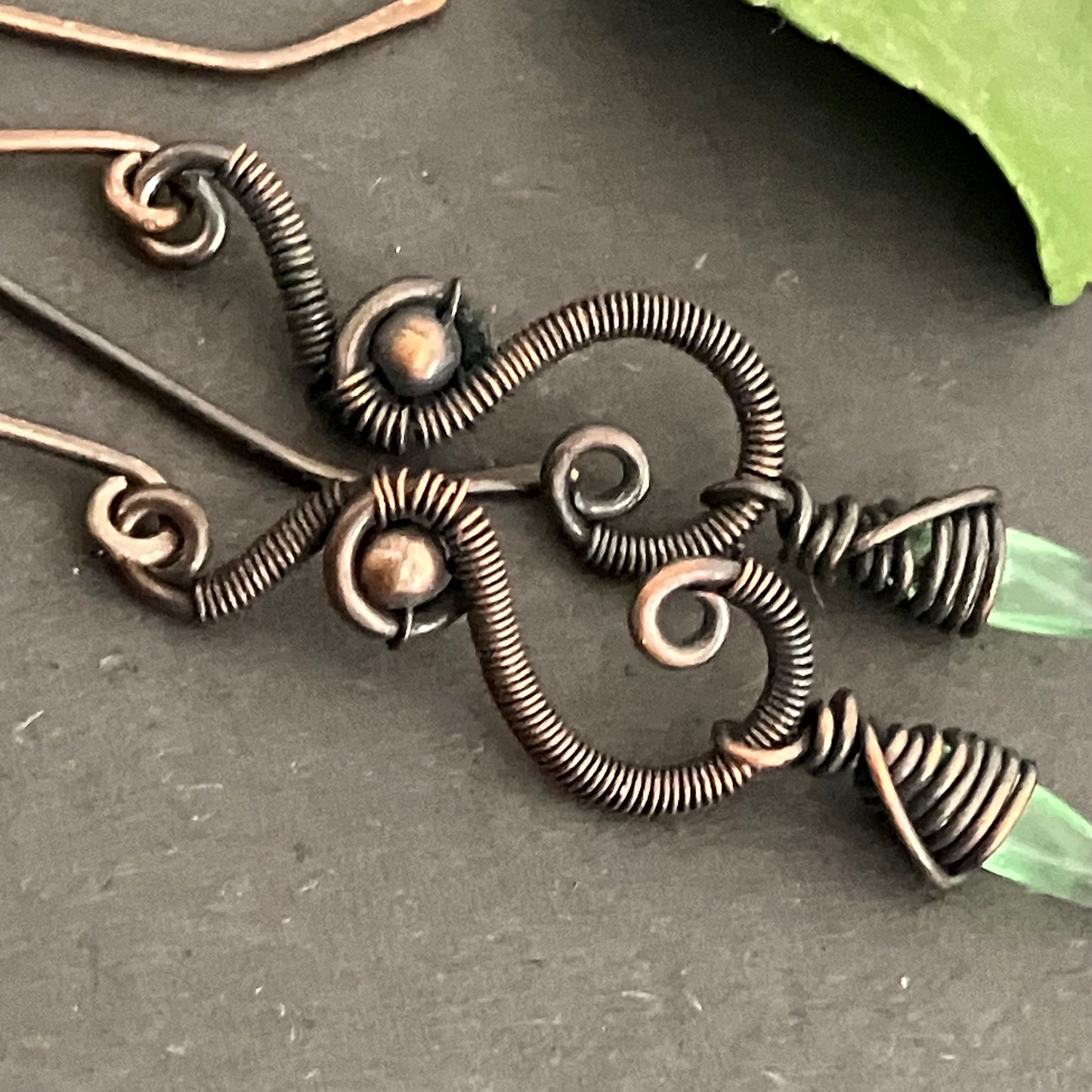 Oxidized copper earrings with green beads.