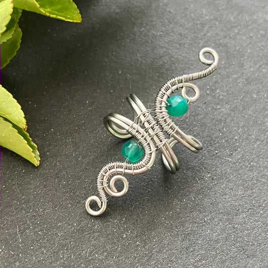 A stainless steel green onyx ear cuff with wire wrapping