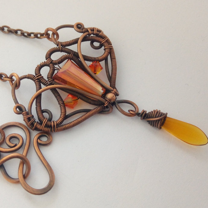 wire wrapped copper necklace with orange glass beads on the pendant