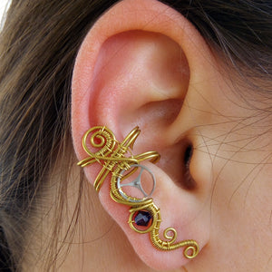 wire wrapped brass ear cuff with a silver gear and a purple swarovski bead