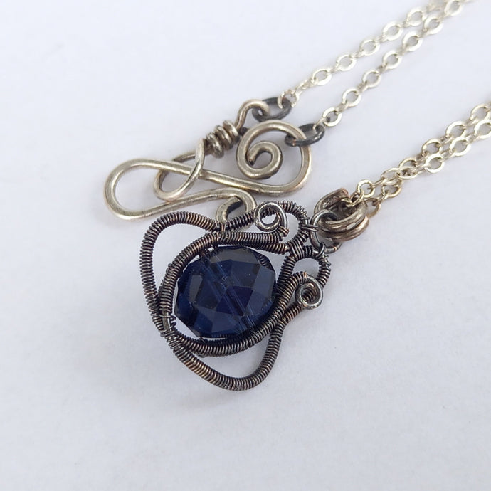 silver wire wrapped necklace with dark blue glass bead