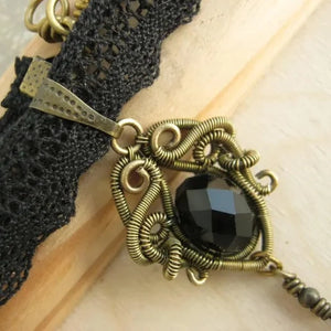 brass wire wrapped pendant with black glass bead on black lace choker 